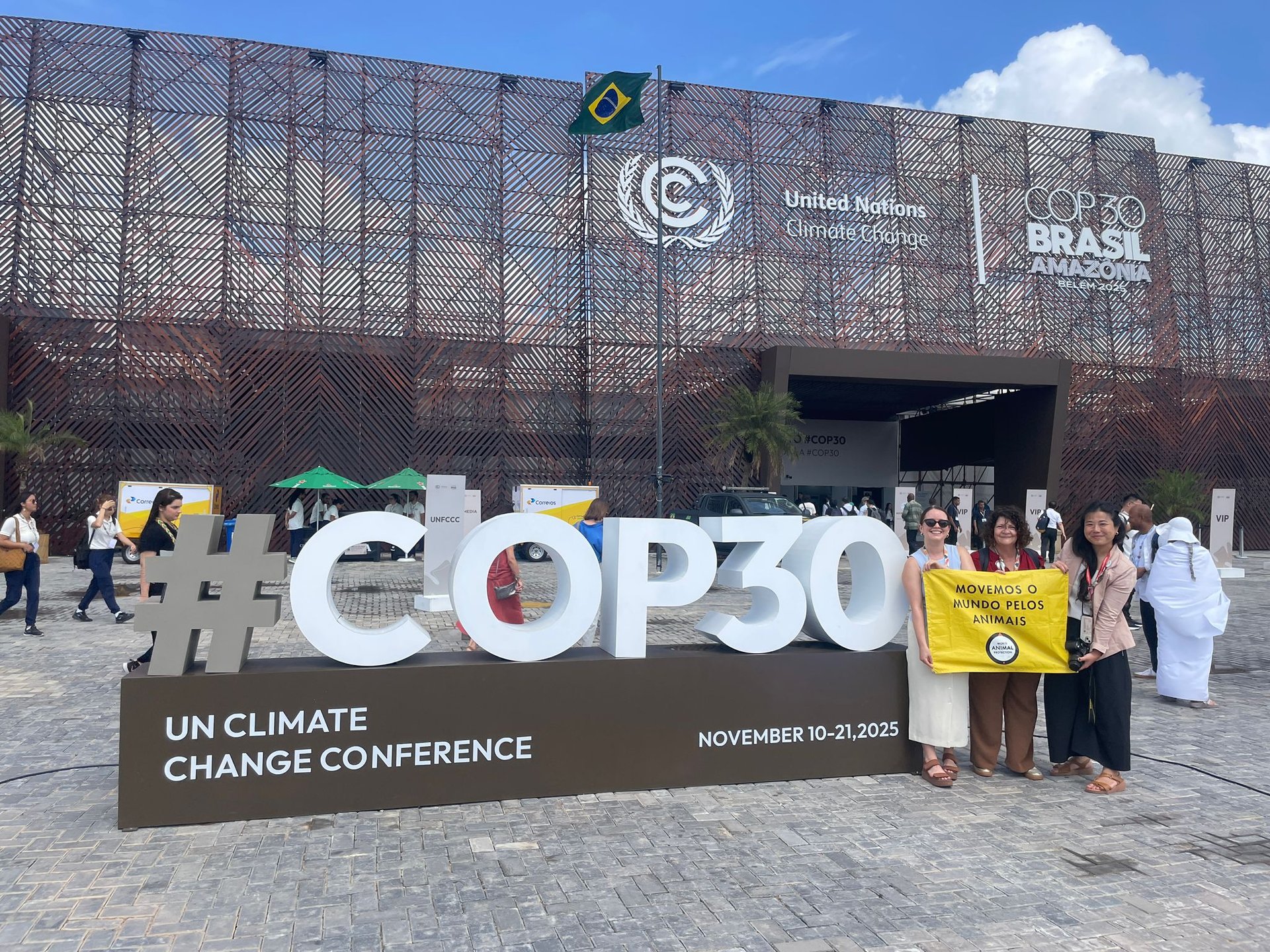 World Animal Protection staff standing beside the large #COP30 sign outside the UN Climate Change Conference venue in Belém.